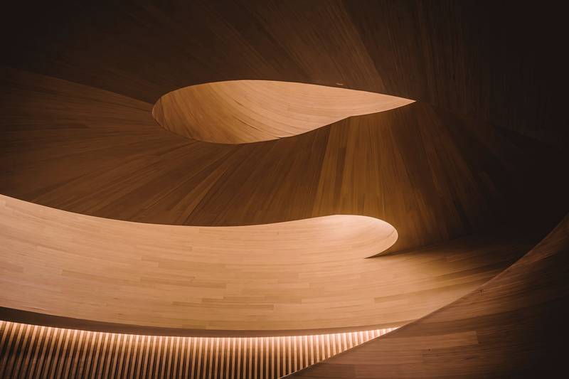 Curva de madera pulida recorrida por una línea de luz