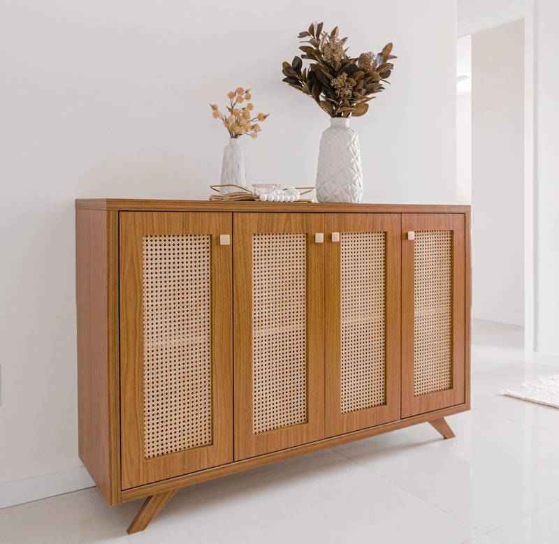Aparador de madera con puertas de rejilla y un jarrón con flores