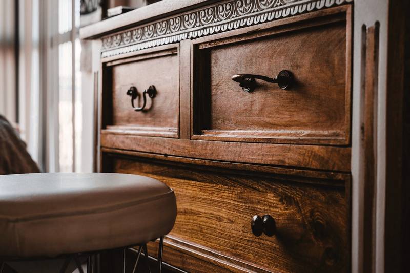 Cómoda de madera oscura con tiradores de hierro