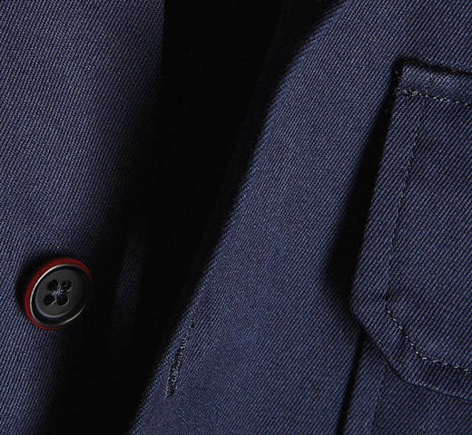 Detalle de un botón y un bolsillo en una prenda azul marino