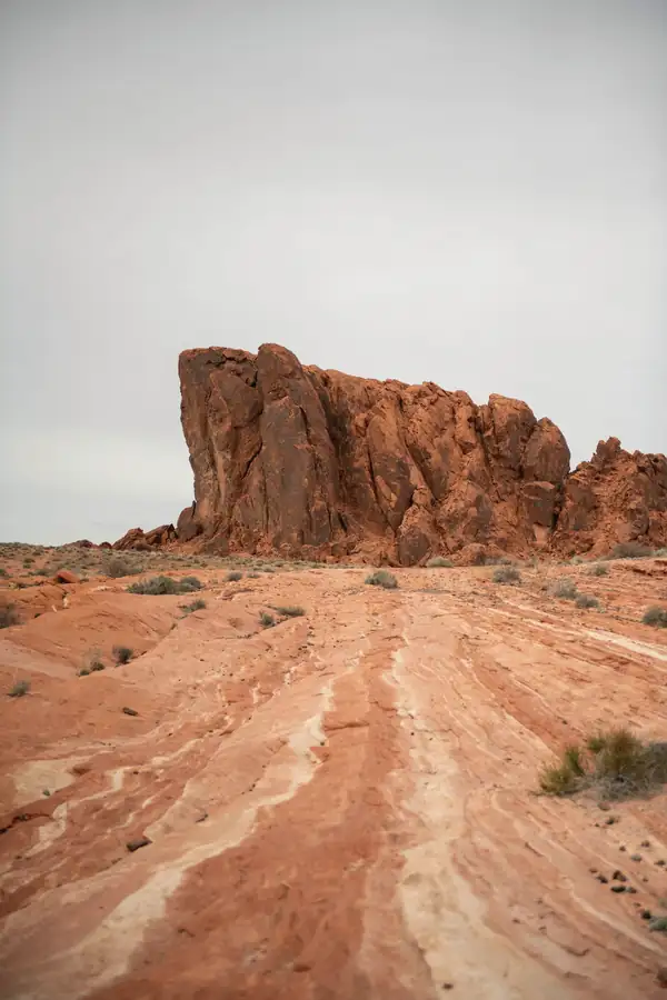 Camino de piedra roja que lleva a una gran roca