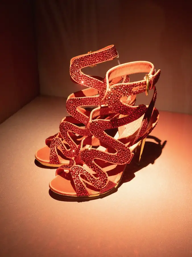 Sandalias rojas de tiras sobre una caja iluminada en rojo