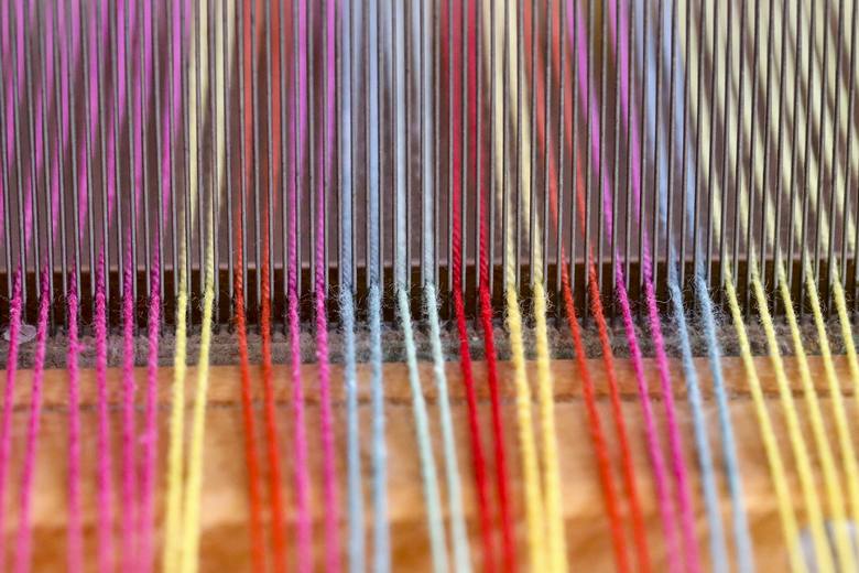 Hilos de colores tensados en un telar