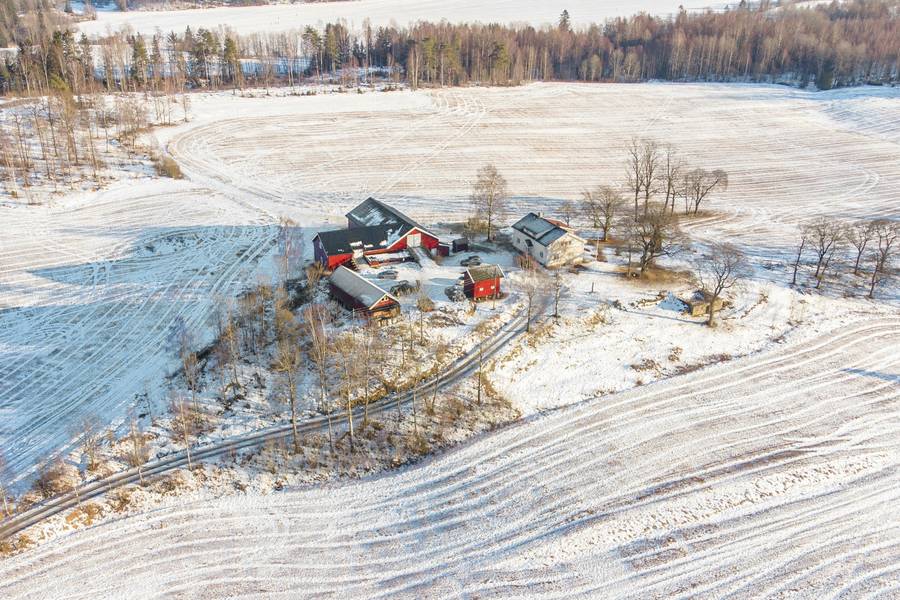 Vista aérea de una casona con su patio de labor, rodeada de campos nevados
