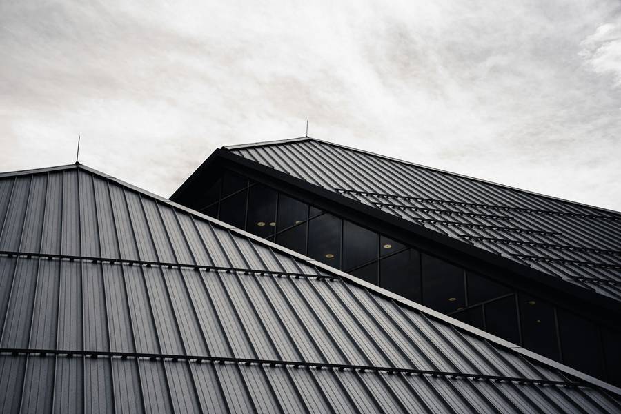 Cubiertas de zinc oscuro que se cruzan contra un cielo cubierto