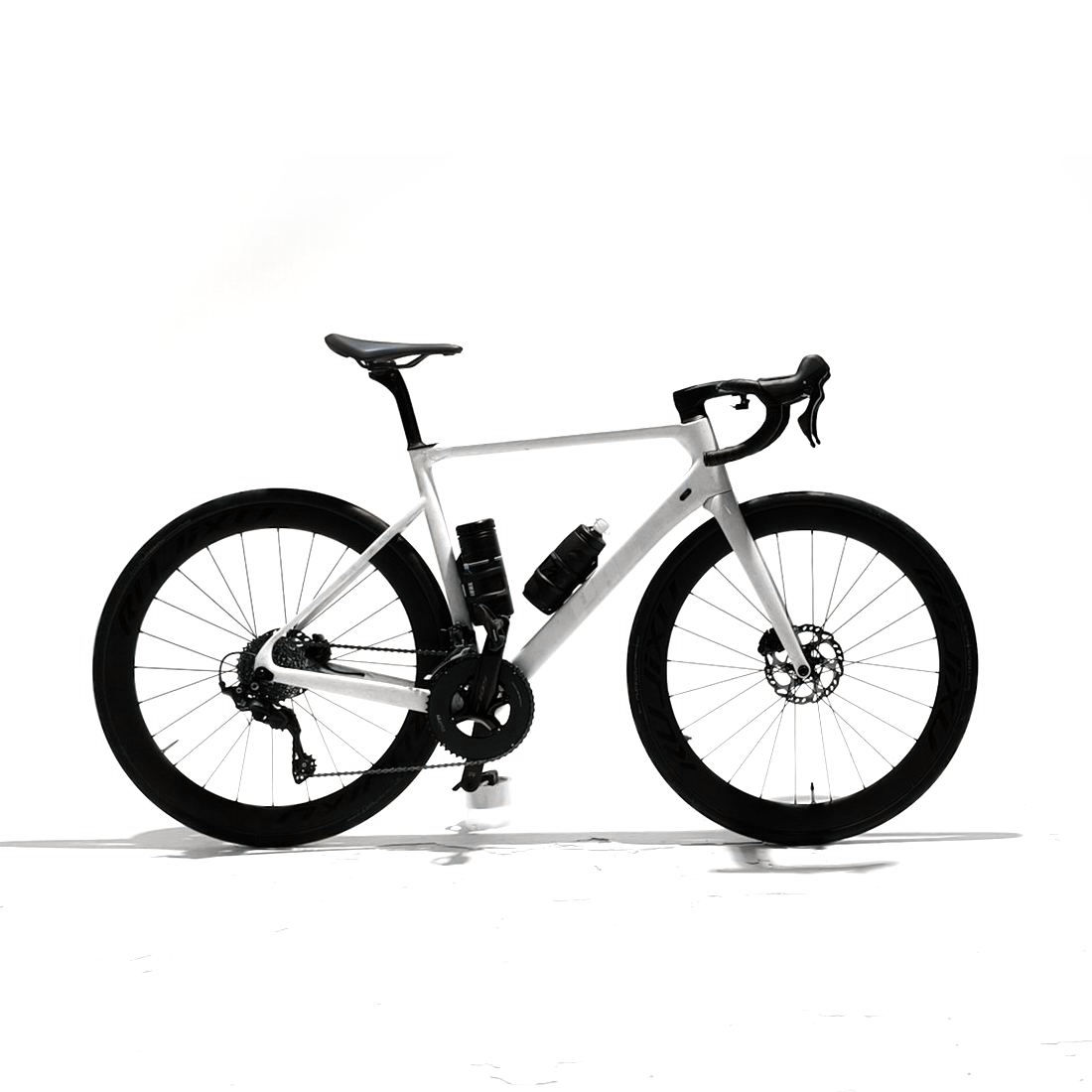 Una bicicleta de carretera blanca y negra sobre un fondo de estudio blanco