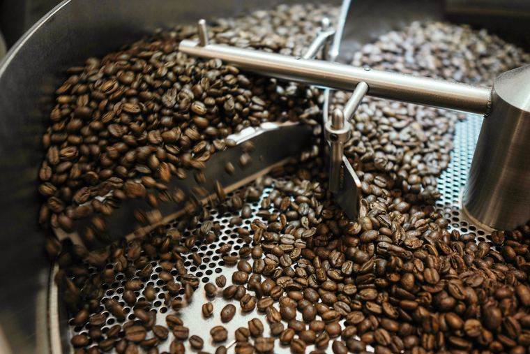 Granos de café recién tostados girando en la bandeja de enfriado
