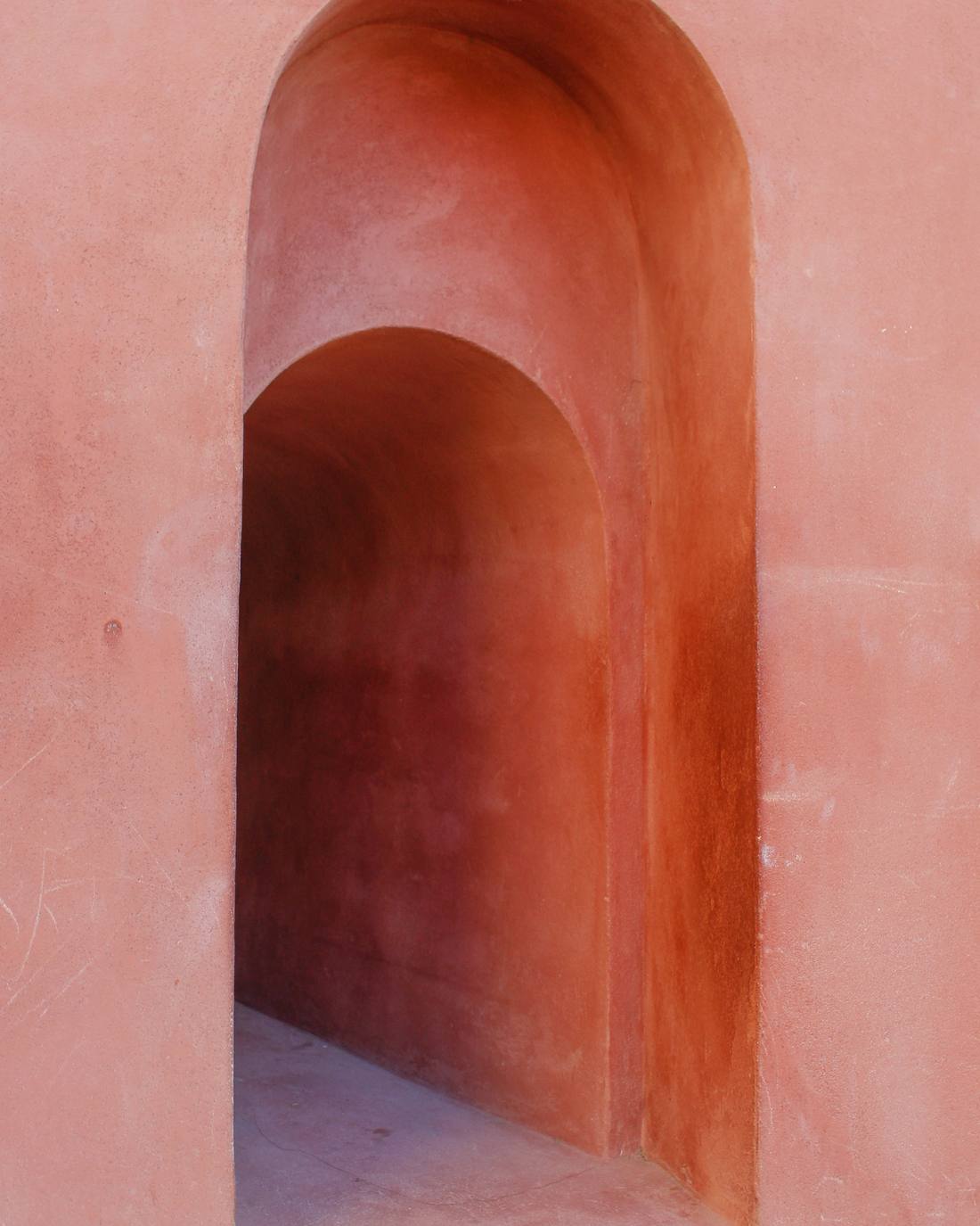 Hornacina con doble arco en un muro de enlucido rosado