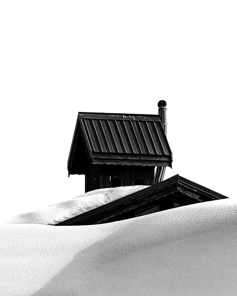 Pequeña cabaña de madera hundida en la nieve