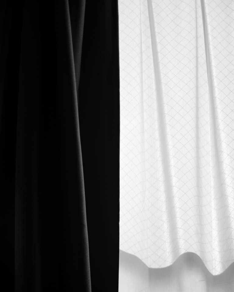 Cortinas de tela blanca y negra caídas en pliegues