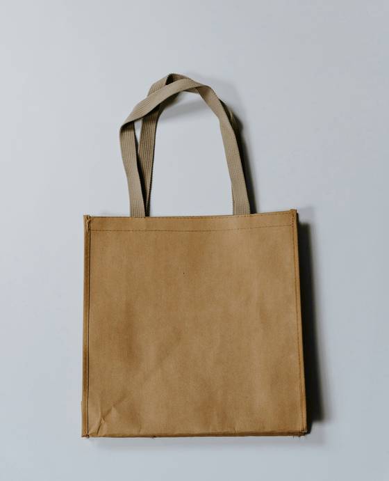 Bolsa de papel kraft lisa sobre un fondo gris azulado