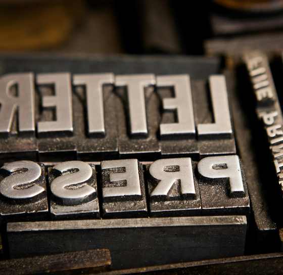 Tipos de metal con las palabras «letter press» en espejo