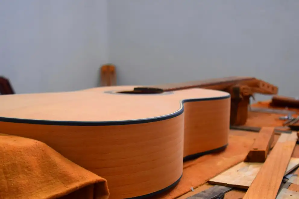 Guitarra en construcción sobre un banco con herramientas