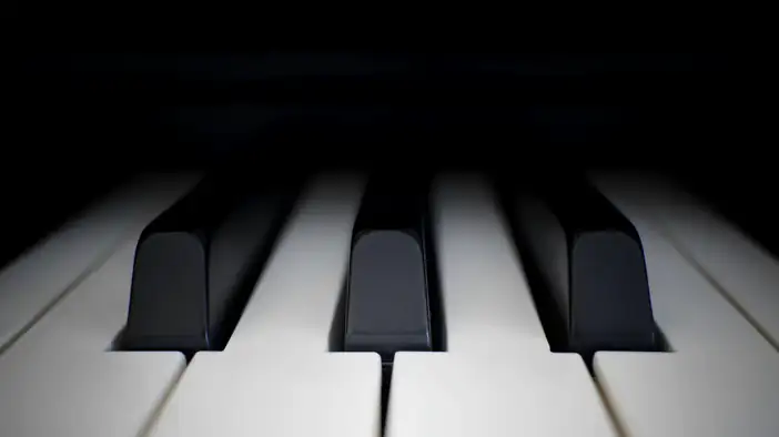 Tres teclas negras de un piano sobre un fondo oscuro
