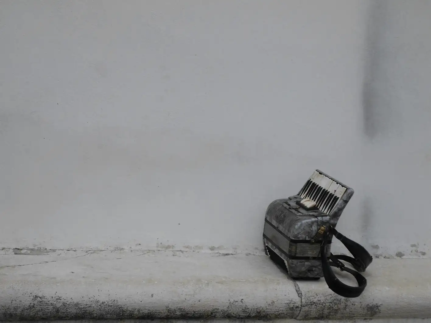 Acordeón pequeño apoyado contra una pared