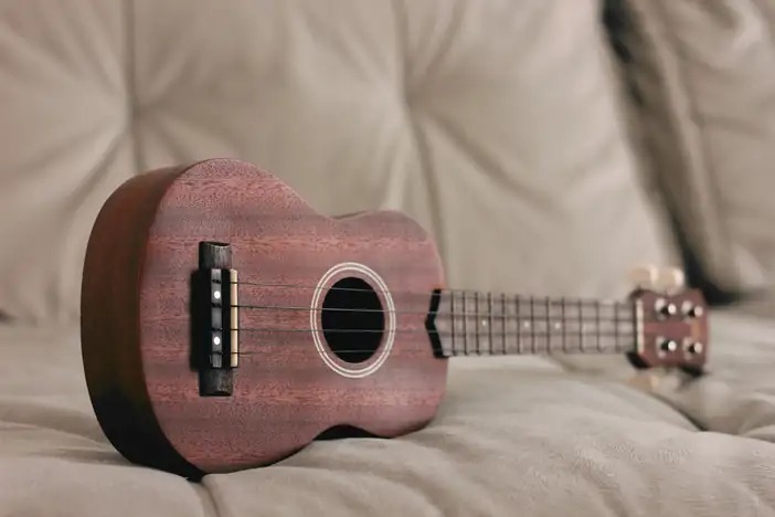 Ukelele sobre un sillón de tela clara