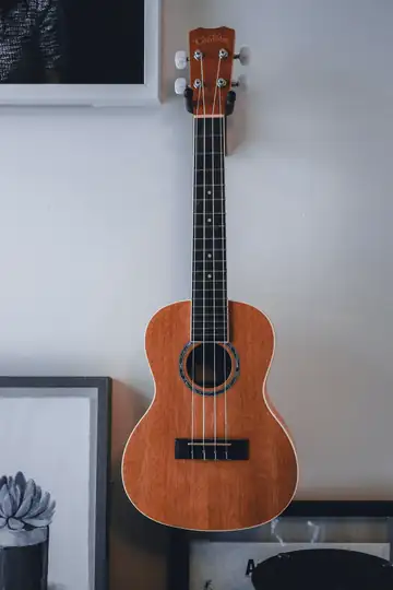 Ukelele colgado de una pared clara