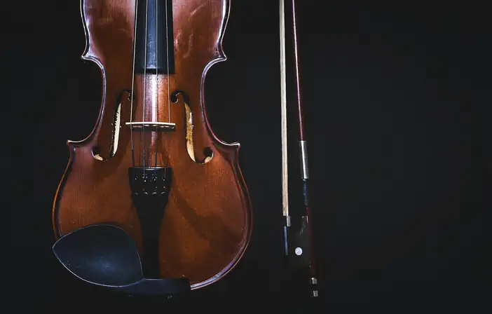Violín y arco sobre un fondo negro
